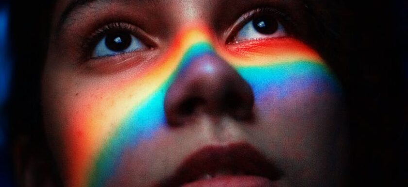 woman with rainbow light reflecting her face